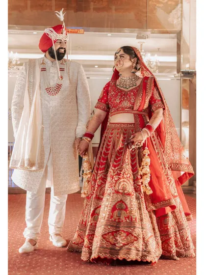 A joyful, candid shot of Ishita and Dipender, their smiles lighting up the frame as they hold hands, perfectly capturing their happiness.