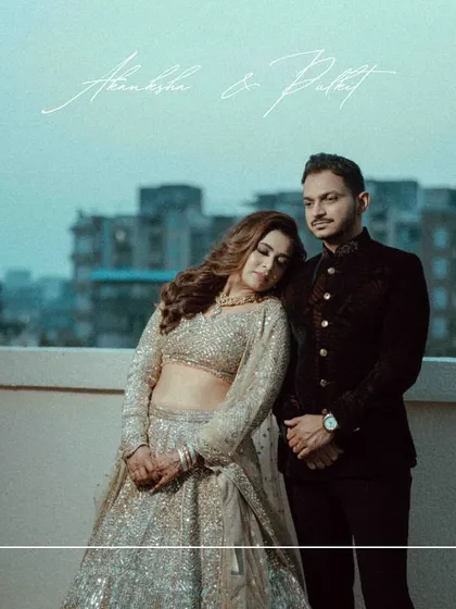 A moody and romantic rooftop portrait from a reception. The bride rests her head on the groom's shoulder against the city skyline, creating a cinematic and intimate feel.