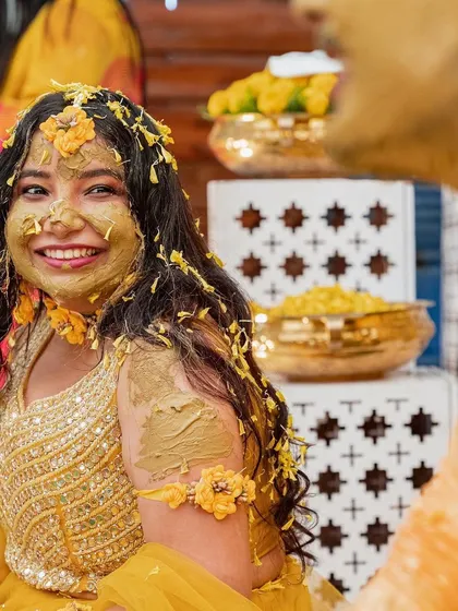 A bride's radiant smile as she is lovingly covered in Haldi paste and flower petals. I focus on capturing the genuine emotions and joy of your wedding ceremonies.