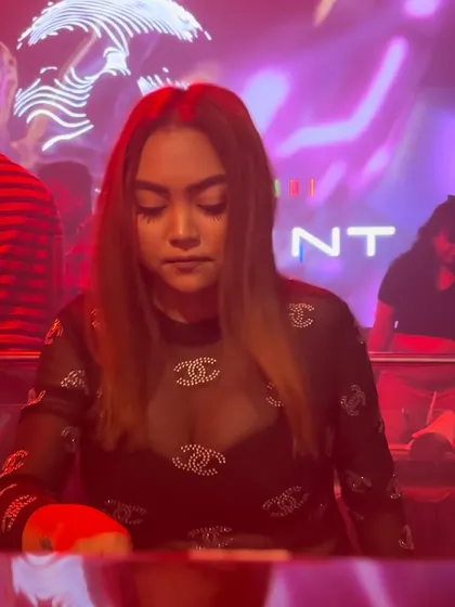 A close-up of me mixing under red lights, fully concentrated on the music.