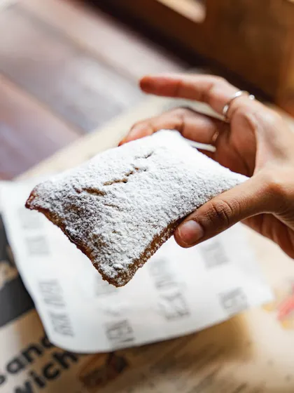 Our sourdough beignets. We use our sourdough starter to give them a unique, slight tang, then fry them until golden and dust generously with powdered sugar.