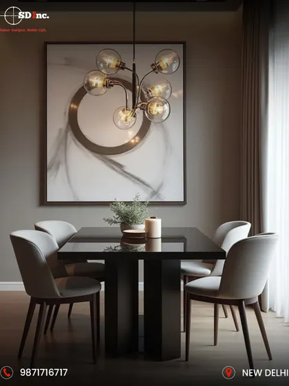A modern and moody dining area with a sleek black table and light grey upholstered chairs. The space is defined by a dramatic globe chandelier and abstract art, creating a sophisticated ambiance for intimate dinners.