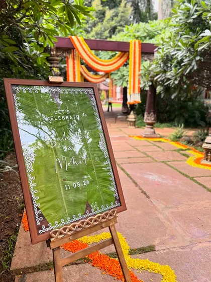 A beautiful welcome sign with calligraphy on a banana leaf, set against a backdrop of a traditional entrance arch.