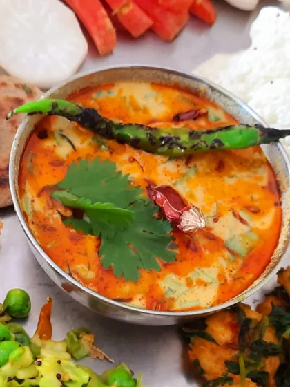 The star of the thali, a creamy and spicy 'dahi tikhari' made with a tempered soy-cashew curd and garnished with a burnt chili.