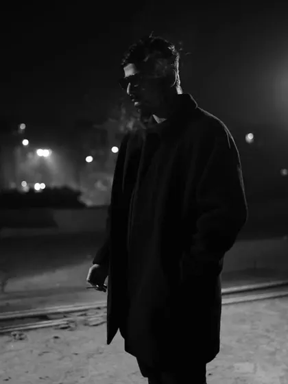 A black and white shot from a night shoot. The smoke and lighting create a mysterious, cinematic feel, much like a deep techno track.