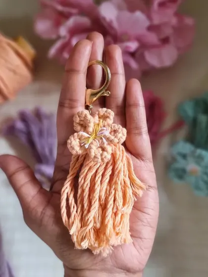 A closer look at our macrame flower keychain in a lovely peach color. These intricate, handmade charms are as cute as they are stylish.