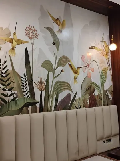 This bedroom accent wall features a whimsical mural of hummingbirds and flowers. The soft colors and graceful design create a peaceful and enchanting atmosphere.