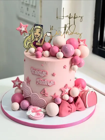 A different take on the Barbie theme, this pink cake is loaded with spheres, stars, and cute accessories like a purse and bow, perfect for celebrating two little queens.