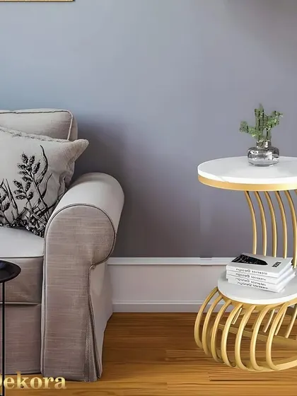 A creative side table with a curved, multi-tube metal base in a gold finish. This piece is designed to sit beside a sofa, offering a stylish surface for drinks, books, or a small lamp.