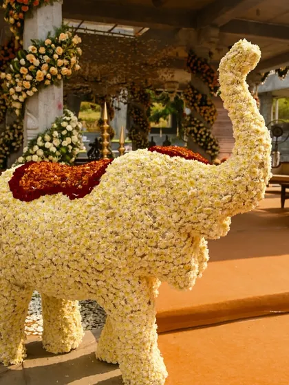 A majestic elephant sculpture made entirely of white and red flowers, a grand and auspicious symbol for any celebration.