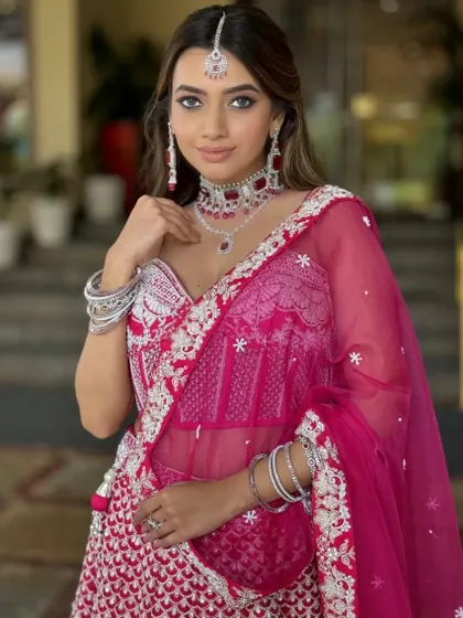 A beautiful bride in a vibrant pink lehenga. The makeup is soft and glamorous, with defined eyes and a flawless base, showcasing the magic of my hands.