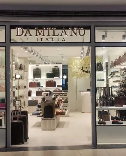 A straight-on view of the Da Milano Dehradun storefront at night, showing how the interior lighting makes the store stand out.
