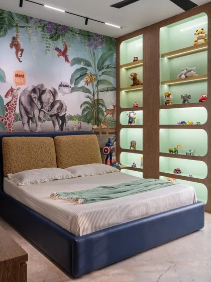 The centerpiece of this jungle-themed room is the bed set against a lively animal mural. We added custom-lit, curved shelving to display a collection of toys, making storage a fun and integral part of the design.