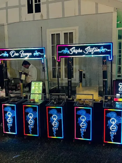 Our modern, portable hookah stations are perfect for sangeets and cocktail parties. This setup includes multiple LED-lit hookah counters, neon signage, and dedicated staff to manage the service.