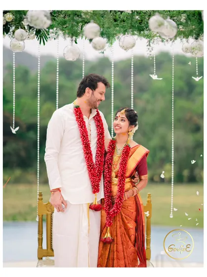 The couple sharing a look under their beautiful floral mandap during their outdoor South Indian wedding ceremony.