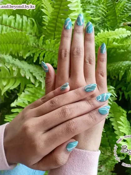 Swirl nail art is so trendy and fun to create. Here is a set of almond-shaped extensions with hand-painted teal and white swirls for a mesmerizing, modern look.