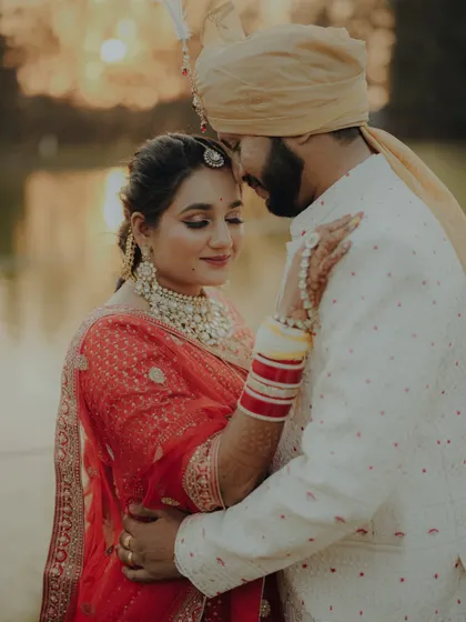An intimate and romantic pre-wedding portrait. The golden hour lighting creates a warm and dreamy atmosphere as the couple shares a tender moment.