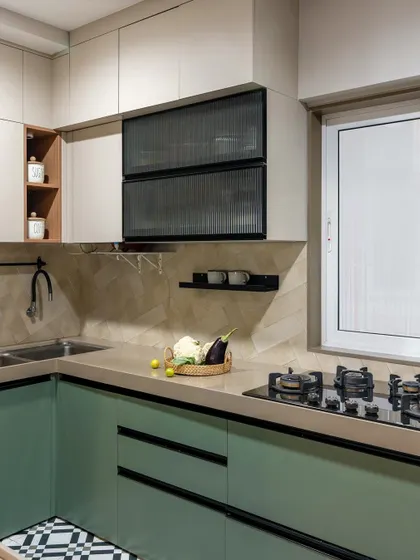 A pop of color makes this kitchen feel fresh and modern. The mint green lower cabinets are paired with neutral upper cabinets and a playful black-and-white tiled floor, creating a space that is full of personality.