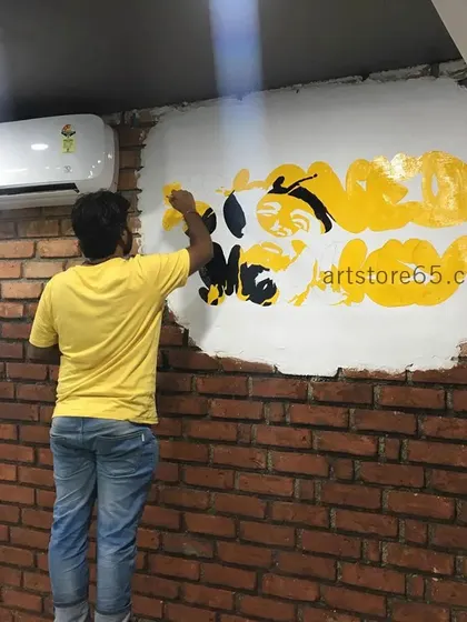 Here is one of our artists at work, painting the 'Stoned Monkey' logo. We can adapt our designs to fit any surface, including uneven or broken-out sections of a wall for a rustic effect.