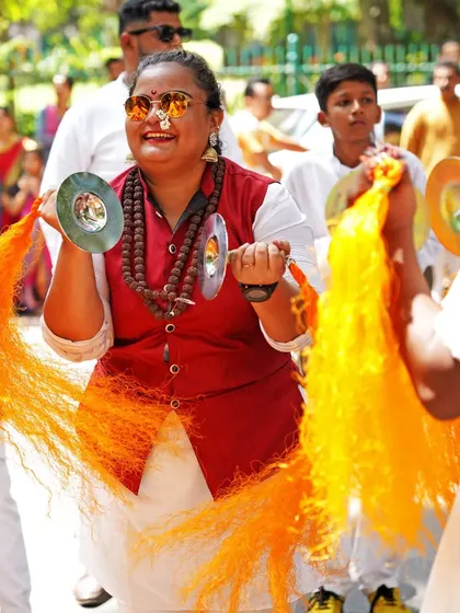 The bright sounds and colors of the procession. This woman plays the taal, or hand cymbals, her joyful expression adding to the celebratory mood of the Gudi Padwa festival.