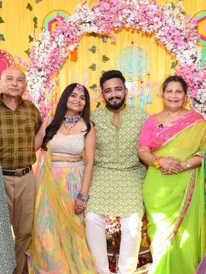 The couple poses with their proud parents and grandparents at the Mehendi ceremony. A cherished family photograph.