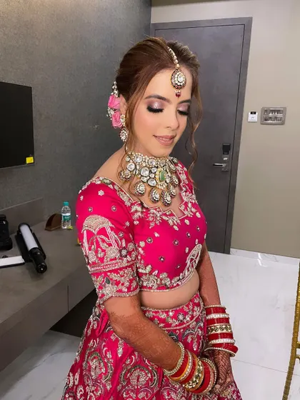 A side view of Vanisha's phera look. The soft, romantic hairstyle with fresh flowers adds a touch of elegance and complements her overall look.