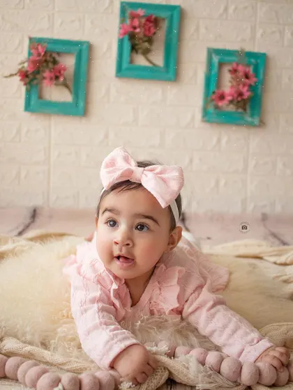 A sweet baby girl crawling on a soft fur rug during her six-month sitter session.