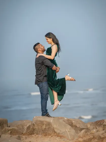 That classic movie lift! This pre-wedding photo on the rocks by the sea is both romantic and powerful, showcasing the couple's connection against a stunning coastal backdrop.