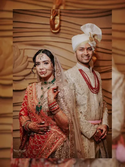 A classic, posed portrait of the couple in their wedding attire. Their confident poses and direct eye contact make for a strong, traditional wedding photograph.