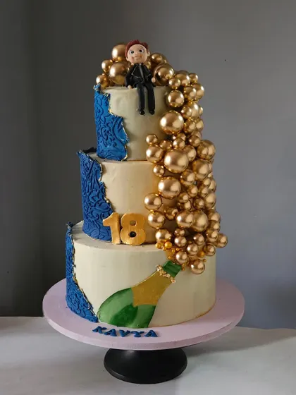 A grand cake for an 18th birthday, this three-tiered design features a cascade of golden bubbles flowing from a champagne bottle. It's a celebratory and luxurious cake, perfect for a milestone event.