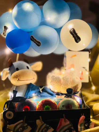 Another view of the baby boy hamper with the warm glow of fairy lights, creating a cozy and inviting look for this special newborn gift.