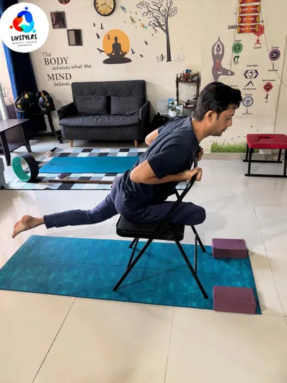A client practices Eka Pada Rajakapotasana (One-Legged King Pigeon Pose) with the support of a yoga chair. This modification helps to safely open the hips and stretch the quadriceps.