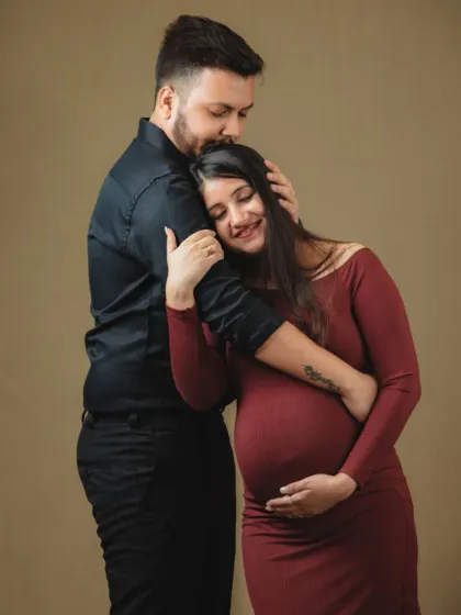 A tender embrace capturing the protective and loving bond between partners during pregnancy. This pose highlights the support and shared emotion of this special time.
