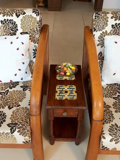 This custom side table showcases a beautiful blend of materials, with hand-painted Azulejos ceramic tiles from Goa inlaid into the solid wood surface. It's a piece that tells a story of travel and personal taste.