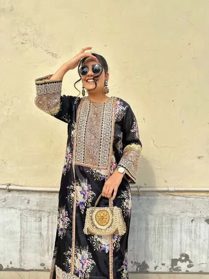 A happy, candid shot showing off the beautiful details of the kurta and the unique, handcrafted bag.