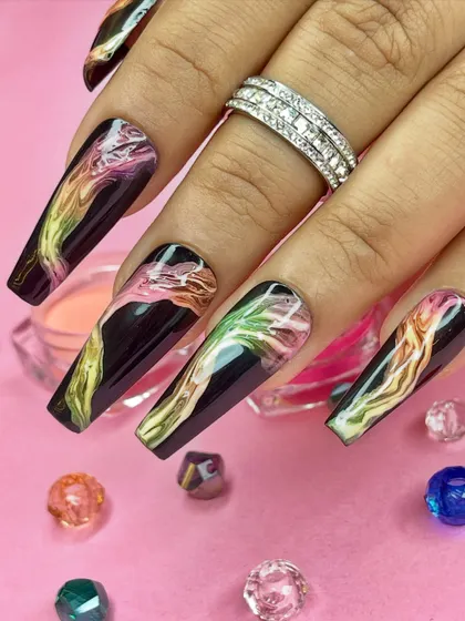 A vibrant, abstract nail art design with a dark base and colorful smoke-like patterns, perfect for a modern Holi celebration.