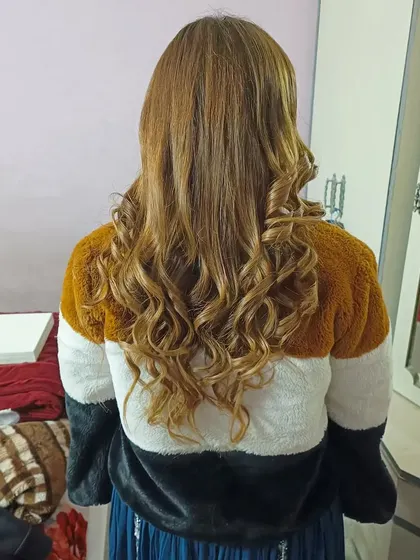 The final result of the open-hair styling, showing soft, natural-looking curls on highlighted hair.