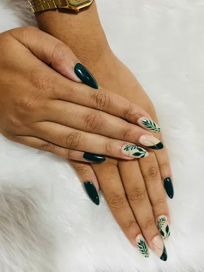 We love a nature-inspired design. This set features elegant, hand-painted green leaves on accent nails, paired with a deep, glossy green polish on almond-shaped extensions.