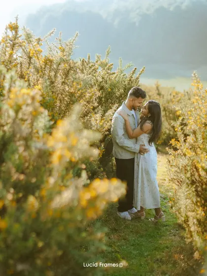 An embrace surrounded by the warm glow of the setting sun and yellow flowers, a perfect example of our natural light portraiture.