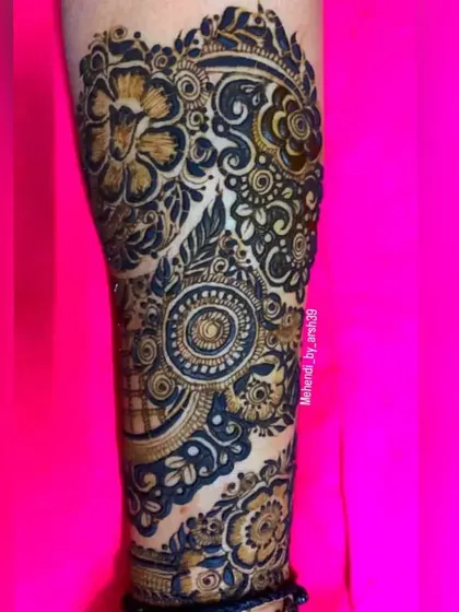 A detailed view of the henna work on the arm. This shot highlights the intricate spiral and floral motifs that make up the larger design.