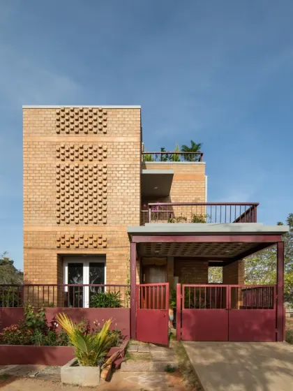 A closer view of the Eesha residence facade, highlighting the patterned brick jali screen. This feature provides ventilation and creates beautiful light play while adding a decorative element to the earth-block construction.