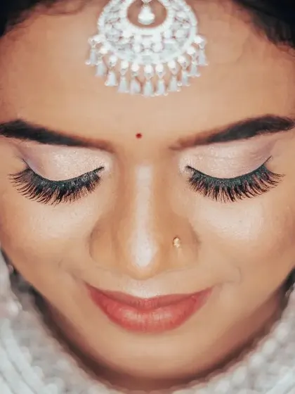 A close-up on the flawless bridal makeup, highlighting the work of the makeup artist and the bride's serene beauty.