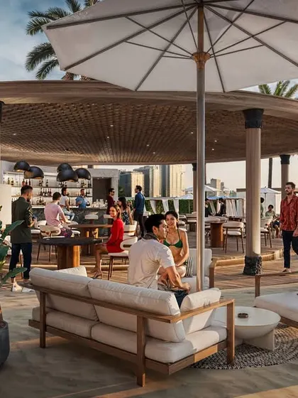 A wider perspective of the Fairmont beach club, showing the relationship between the bar, lounge seating, and the beach in the background.