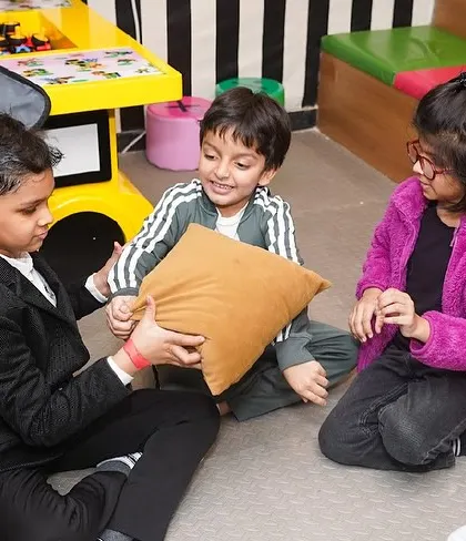 Kids playing pass the parcel, a classic party game that we organize to keep the celebration structured and fun.