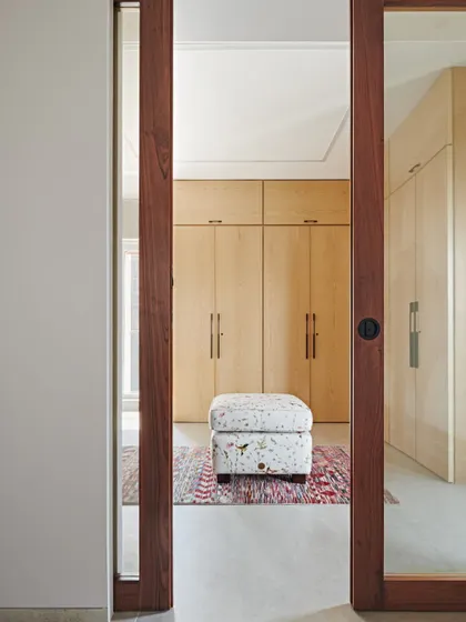 We believe in maximizing functionality through smart planning. This view into a walk-in closet at the Maximum City Duplex shows our approach to creating ample storage that is seamlessly integrated into the bedroom's design.