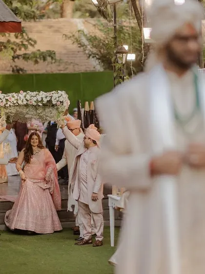 The bride's grand entrance under a 'phoolon ki chadar', with the groom waiting anxiously.