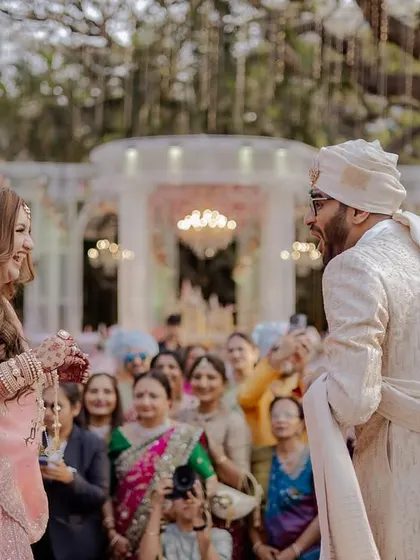 A candid moment of laughter between the couple right before the Varmala.