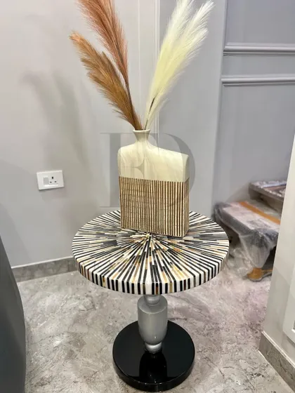 This side table features a stunning tabletop with a radial pattern of bone inlay. Paired with a modern vase, it becomes a small but impactful decorative moment.