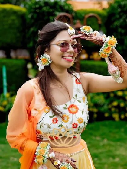 A candid shot of the bride, her beautiful mehendi stain visible as she enjoys her haldi or sangeet ceremony.
