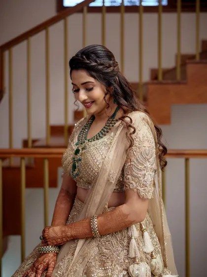 A portrait of a smiling bride in a beautiful golden lehenga, her happiness radiating as much as the intricate embroidery on her outfit.